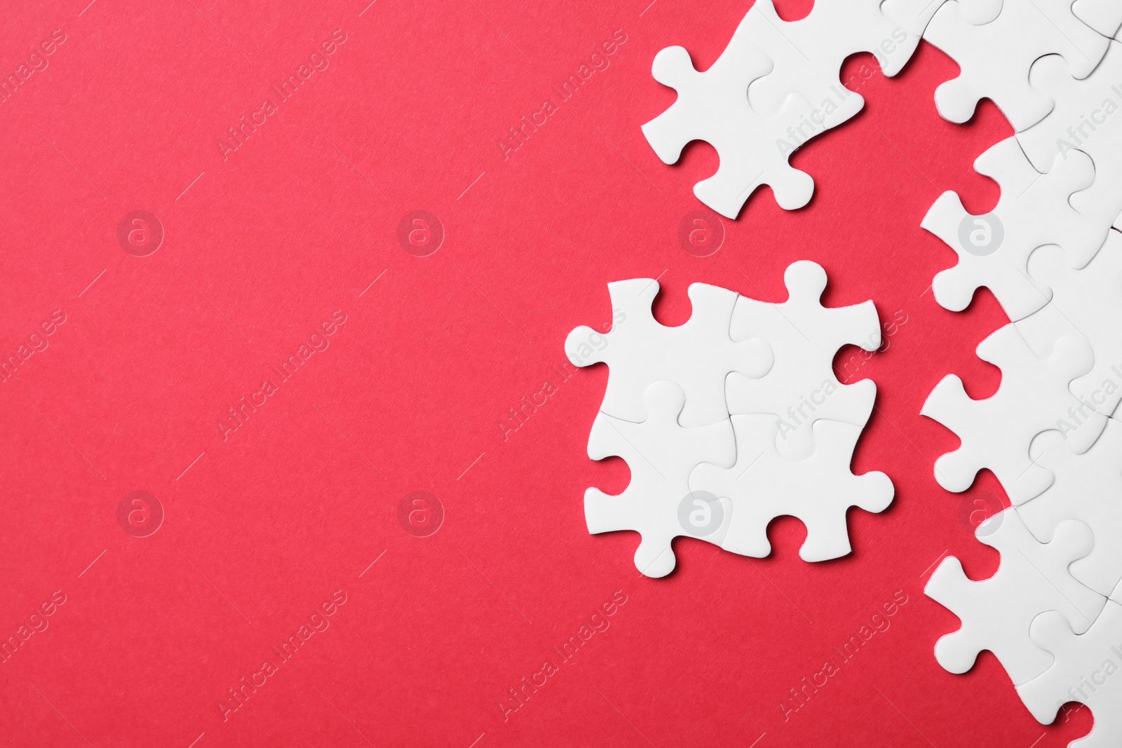 Photo of Blank white puzzle pieces on red background, flat lay. Space for text