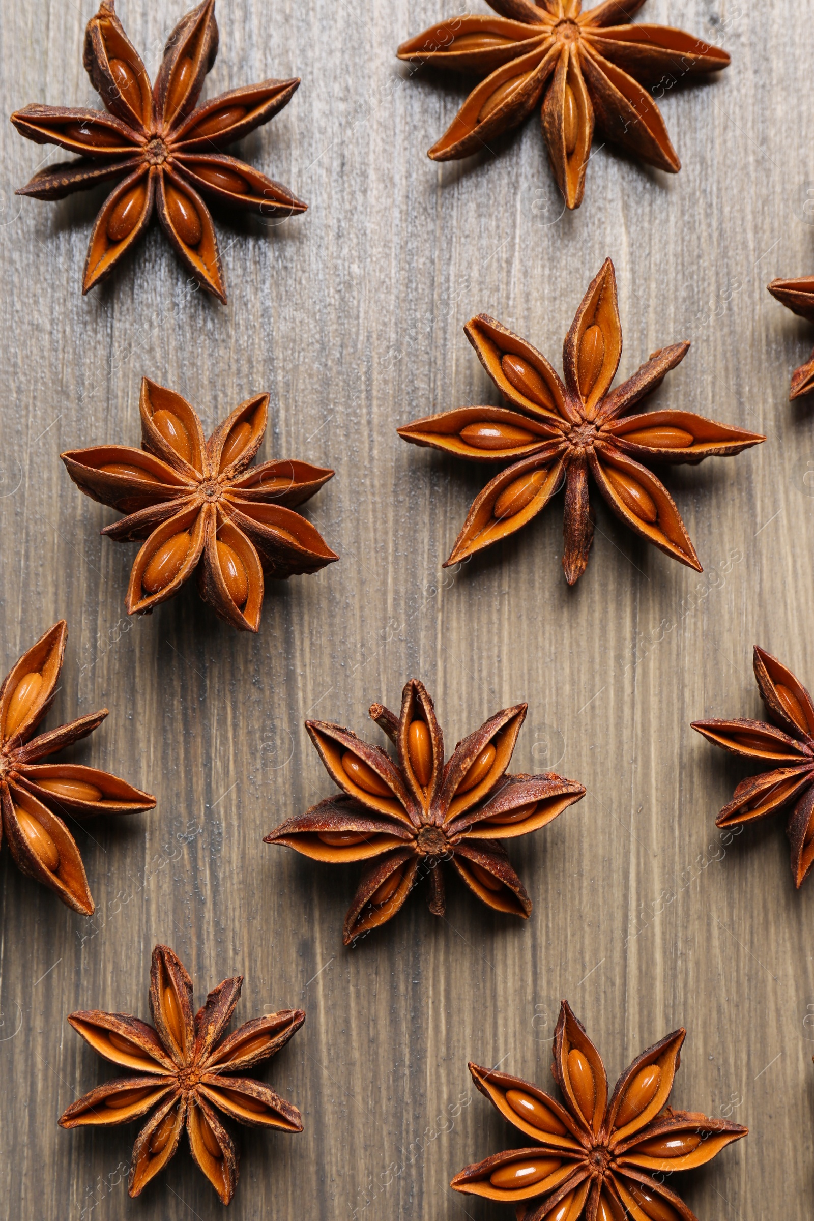 Photo of Aromatic anise stars on wooden table, flat lay