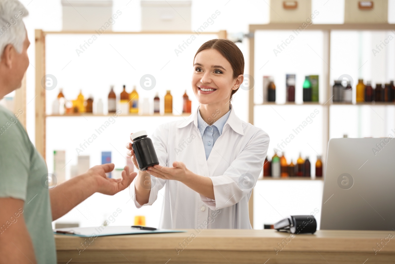 Photo of Pharmacist giving medicine to customer in drugstore