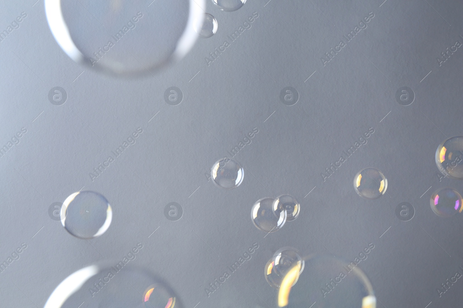 Photo of Beautiful transparent soap bubbles on gray background