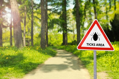Image of Warning sign Beware of ticks in forest on sunny day