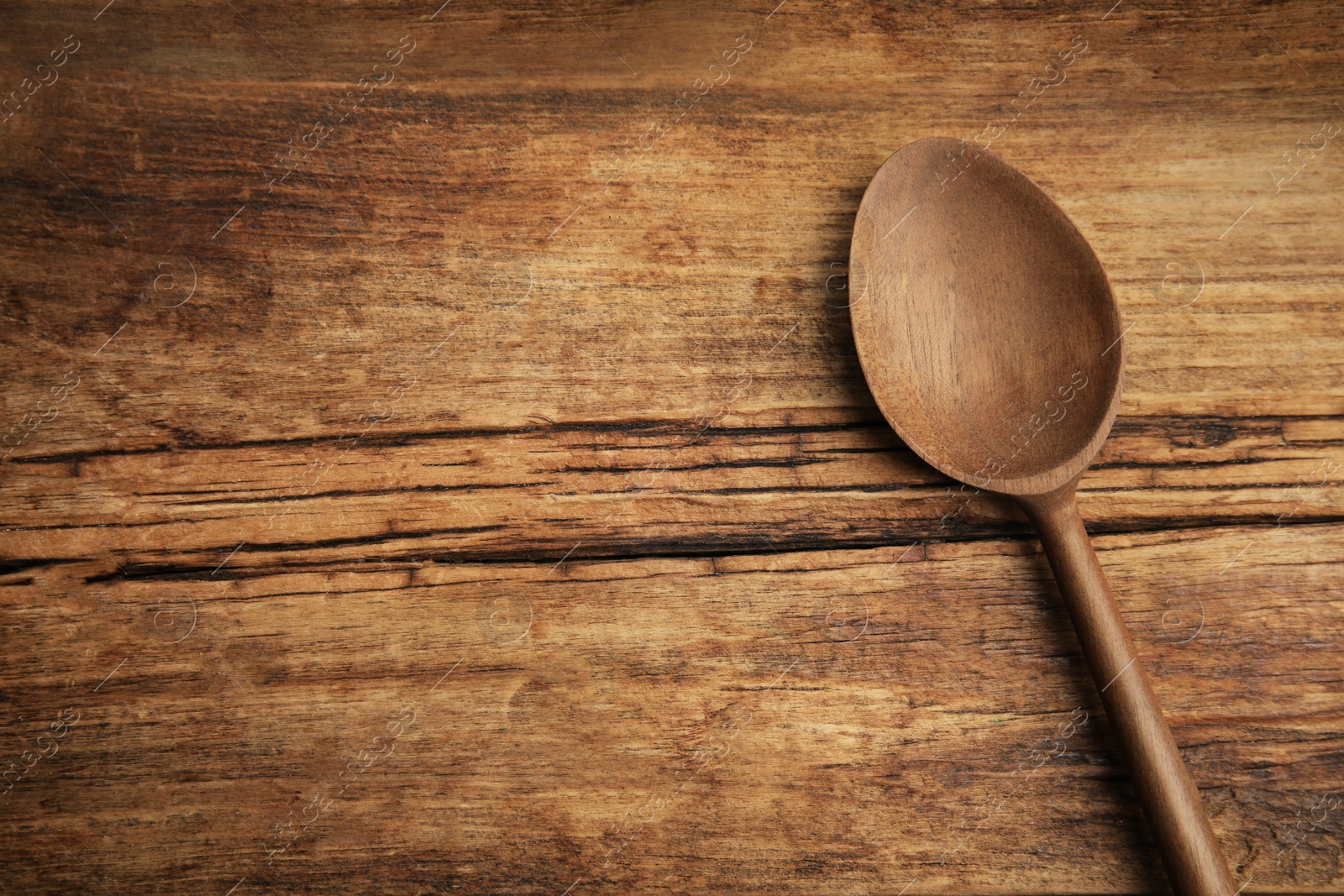 Photo of Handmade wooden spoon on rustic table, top view. Space for text