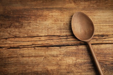 Photo of Handmade wooden spoon on rustic table, top view. Space for text