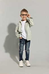 Photo of Fashion concept. Stylish boy posing on light grey background