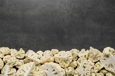 Photo of Cut fresh raw cauliflower on grey table, flat lay. Space for text