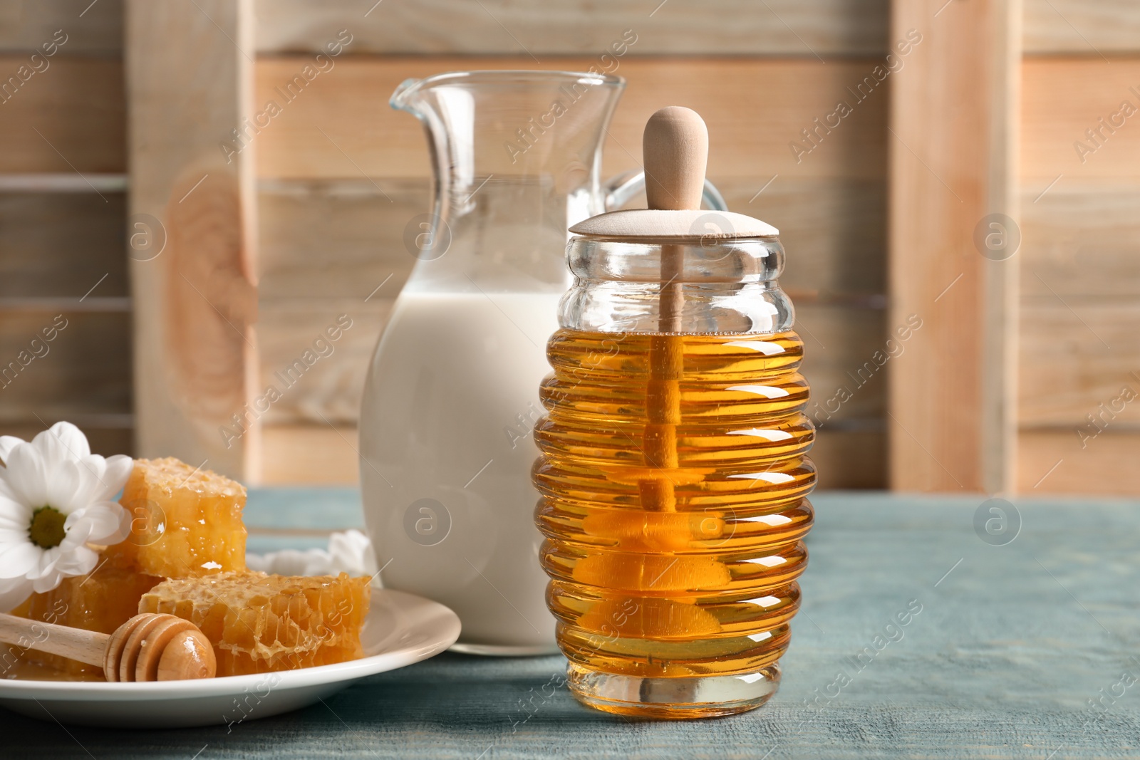 Photo of Beautiful composition with milk and honey on wooden table