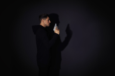 Photo of Professional killer with gun on black background. Space for text