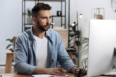 Man working on computer at table in office