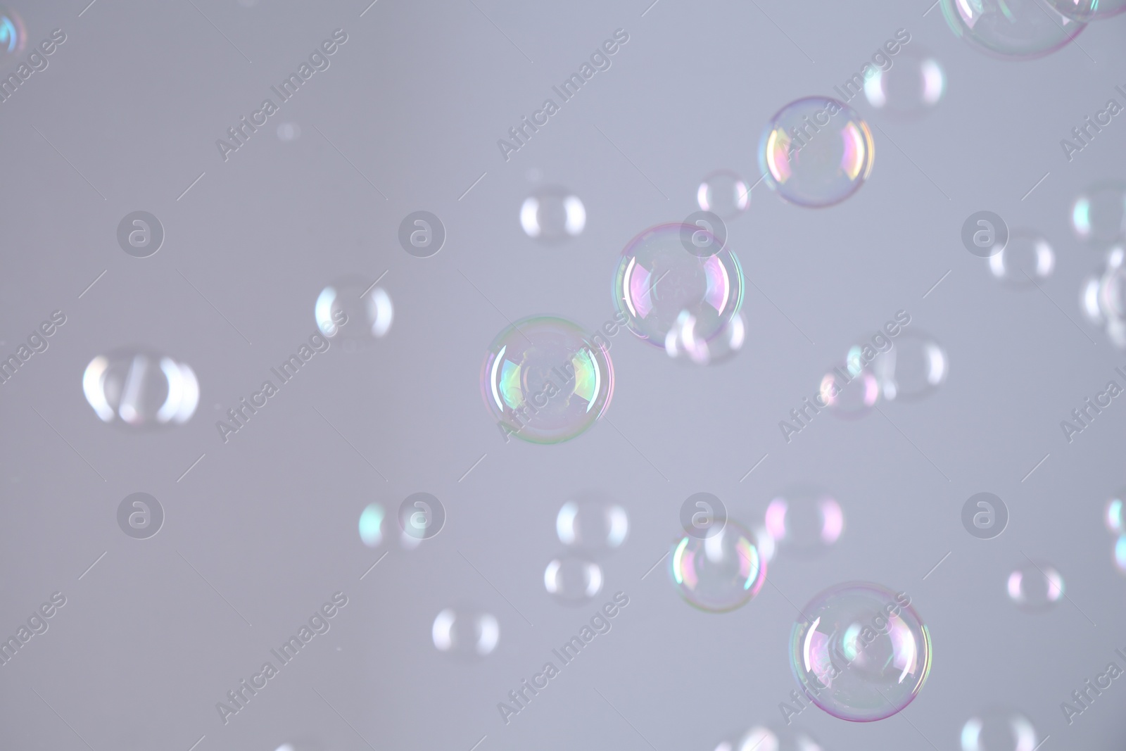 Photo of Beautiful transparent soap bubbles on grey background
