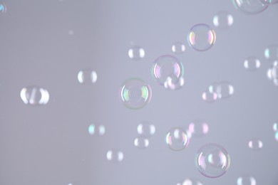 Photo of Beautiful transparent soap bubbles on grey background