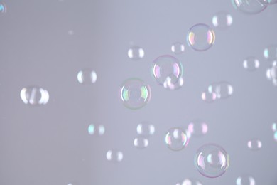 Beautiful transparent soap bubbles on grey background