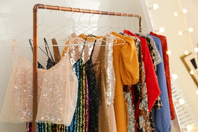 Photo of Rack with different stylish women's clothes indoors