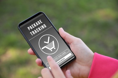 Image of Woman tracking parcel via smartphone outdoors, closeup
