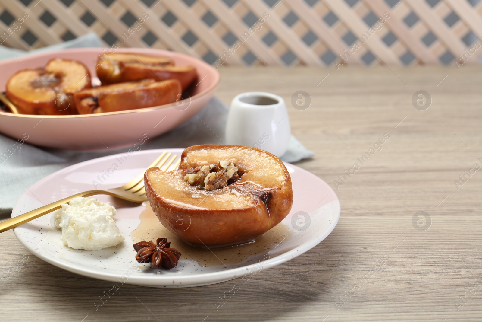 Photo of Delicious quince baked with honey and walnuts on wooden table