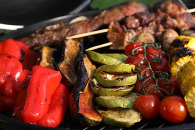 Tasty meat and vegetables on barbecue grill, closeup view