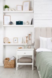 Photo of Wall shelves with beautiful decor elements in stylish bedroom interior
