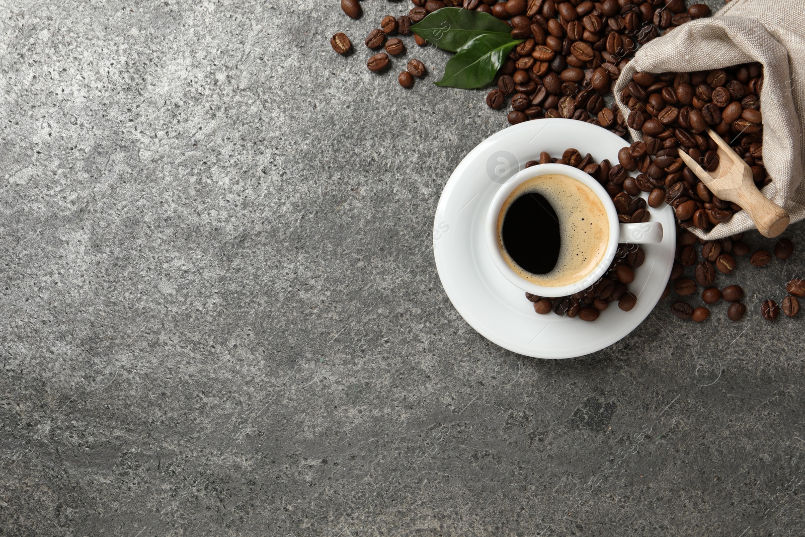 Photo of Cup of aromatic hot coffee and beans on grey table, lat lay. Space for text