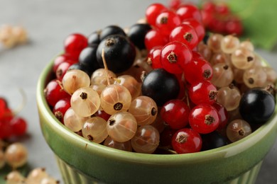 Photo of Different fresh ripe currants in bowl, closeup