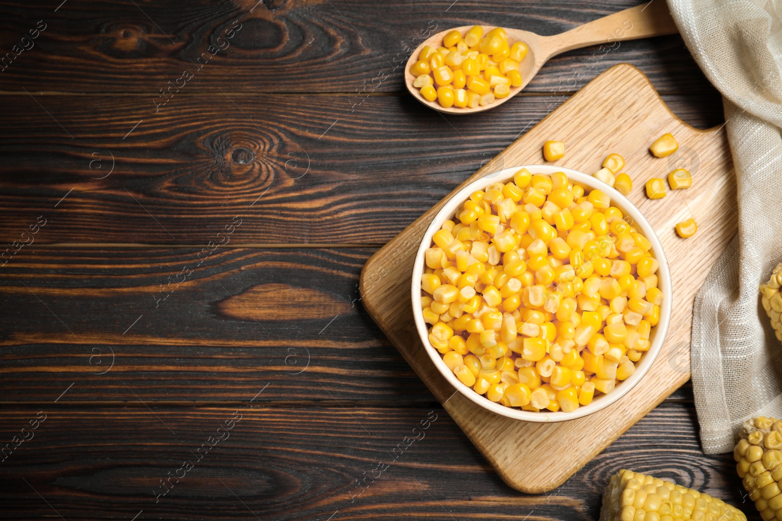 Photo of Delicious canned corn in bowl on wooden table, flat lay. Space for text