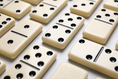 Photo of Classic domino tiles on white background, closeup