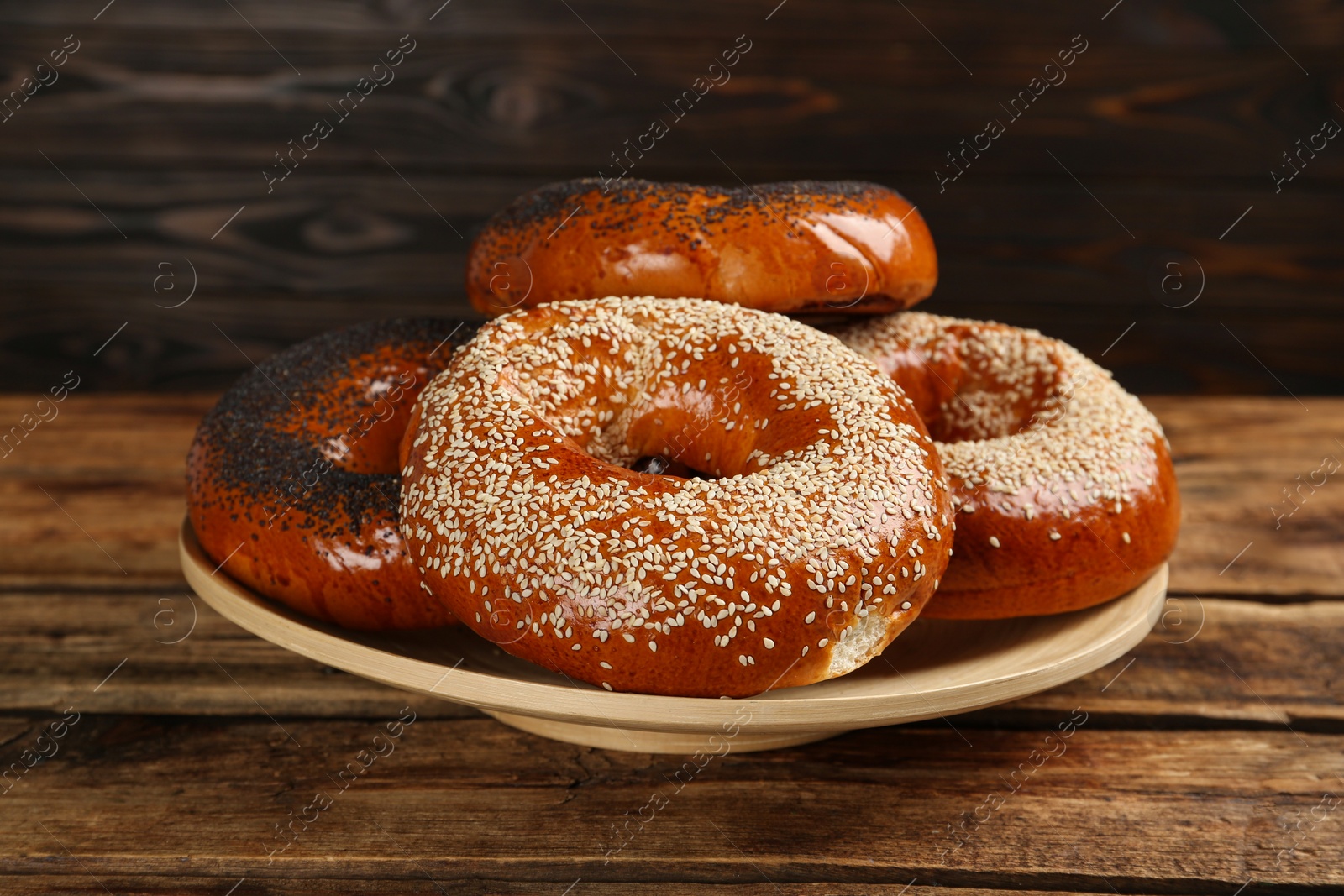 Photo of Many delicious fresh bagels on wooden table