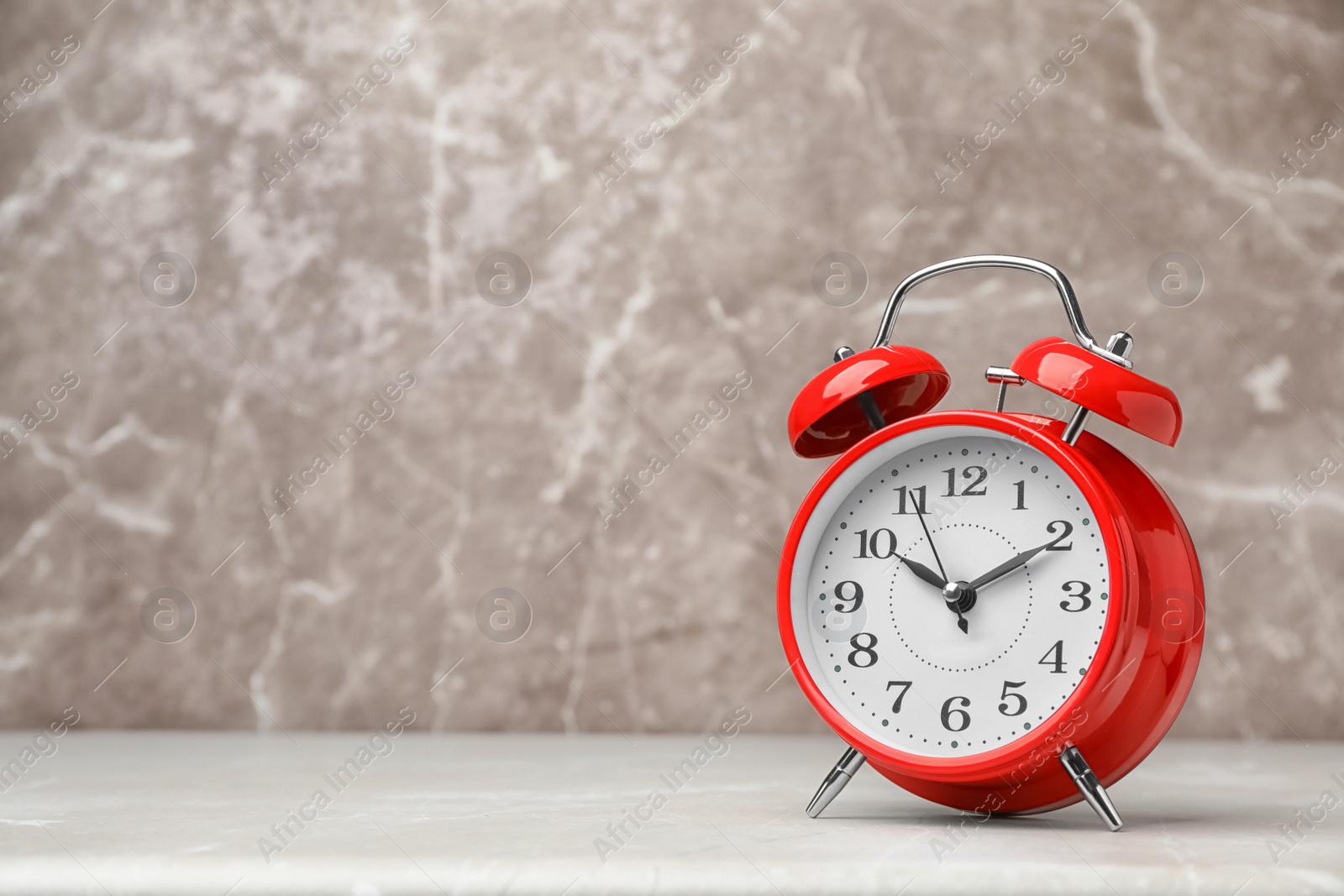 Photo of Alarm clock on table against grey background. Time concept