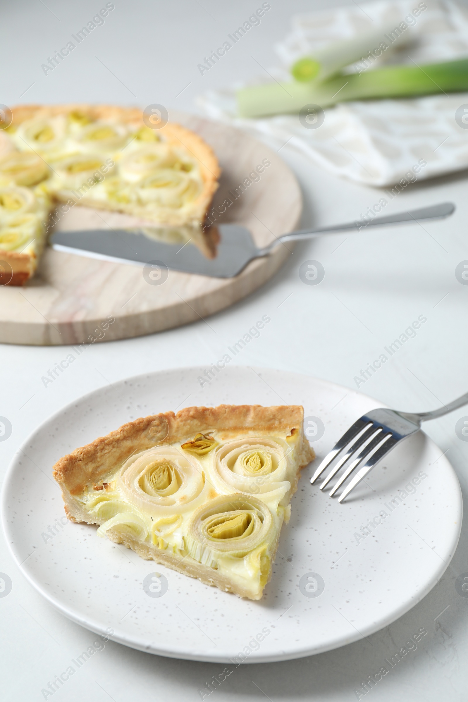 Photo of Piece of tasty leek pie served on white table