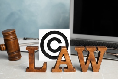 Photo of Composition with word LAW, gavel and copyright symbol on table