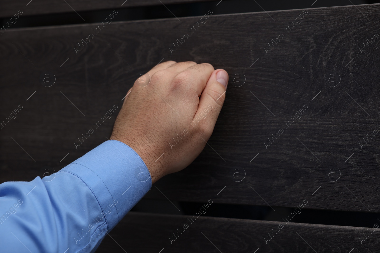 Photo of Collection agent knocking on wooden door, closeup