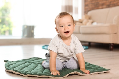 Photo of Adorable little baby sitting on floor at home