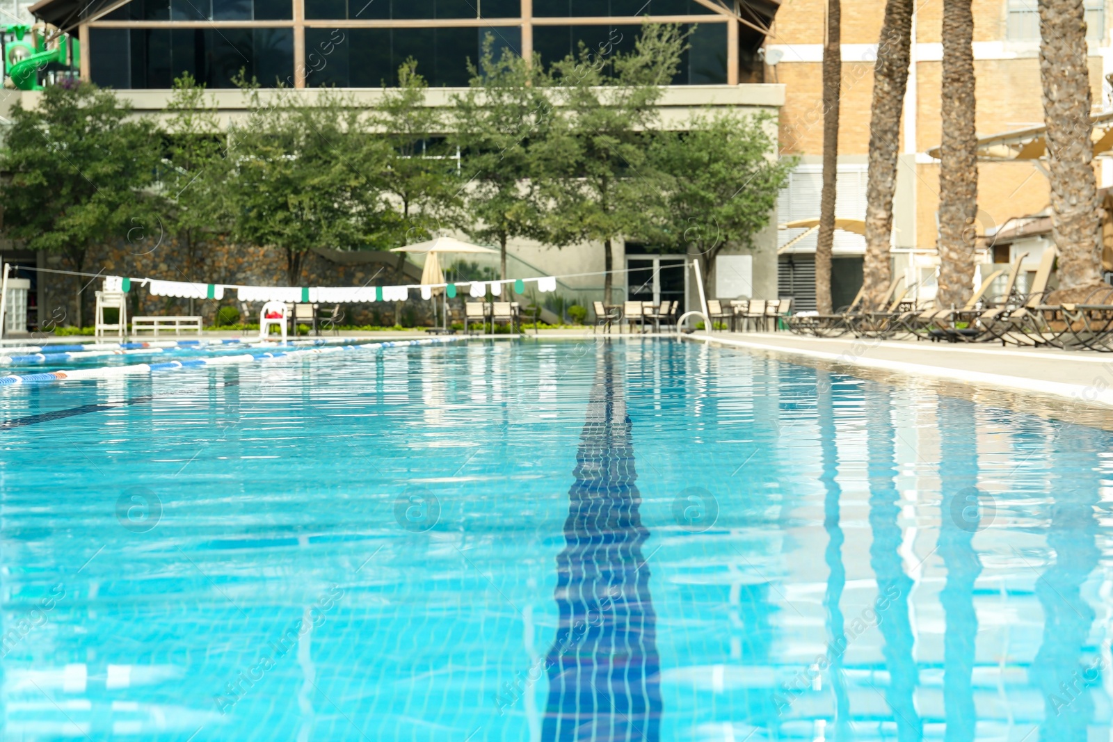 Photo of Swimming pool and sunbeds at luxury resort