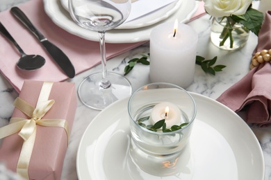 Elegant festive table setting on white marble background, closeup