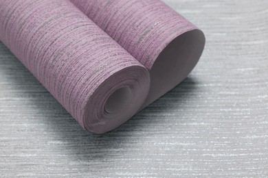 Image of One pink wallpaper roll on light grey background, closeup