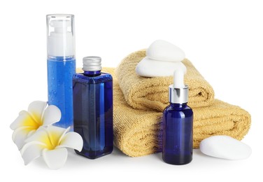 Spa composition. Bottles of cosmetic products, towels, stones and plumeria flowers isolated on white