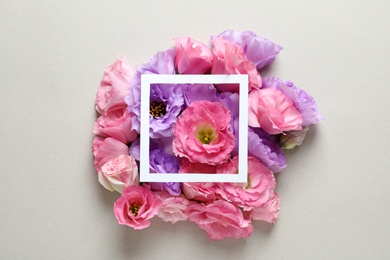 Photo of Beautiful Eustoma flowers and frame on gray background