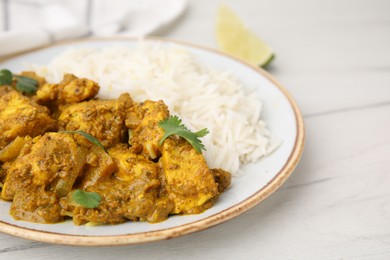 Photo of Delicious chicken curry with rice on white wooden table