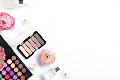 Flat lay composition with different makeup products and beautiful spring flowers on white background, space for text