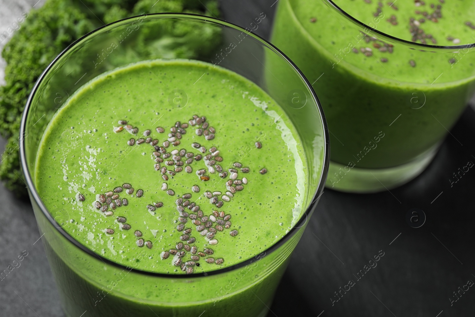 Photo of Tasty kale smoothie with chia seeds on table, closeup