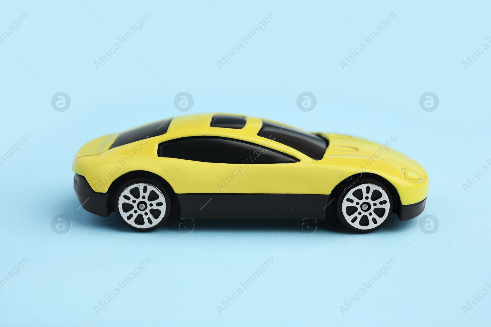 Photo of One yellow car on light blue background. Children`s toy