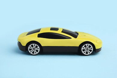 Photo of One yellow car on light blue background. Children`s toy