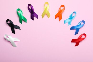 Photo of Colorful ribbons on pink background, flat lay with space for text. World Cancer Day