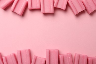 Photo of Tasty chewing gums on pink background, flat lay. Space for text