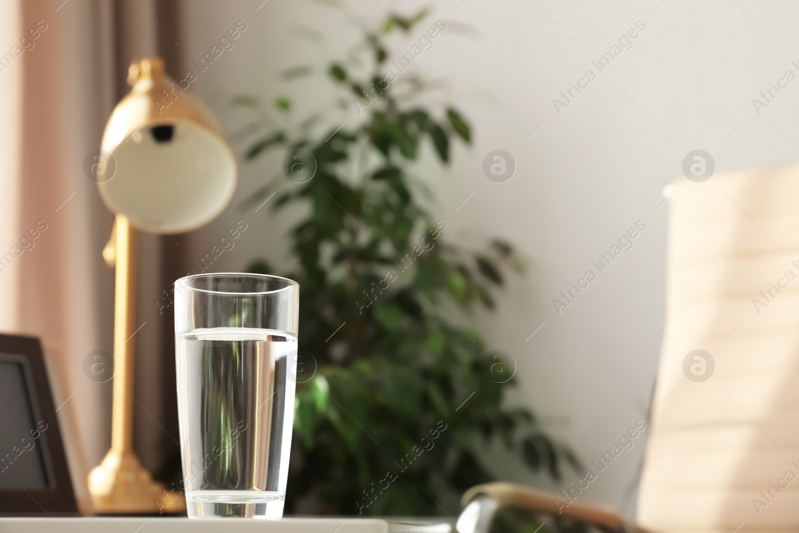 Photo of Glass of fresh water on table indoors. Space for text