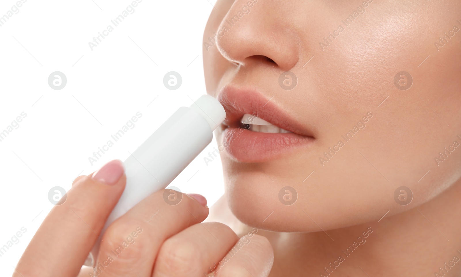 Photo of Young woman with cold sore applying lip balm against white background, closeup