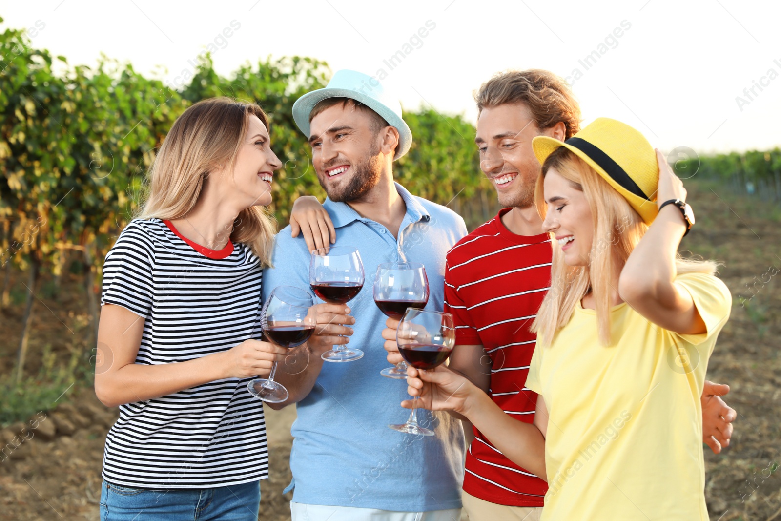 Photo of Friends tasting wine and having fun on vineyard picnic