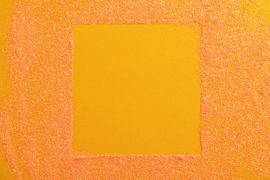 Photo of Frame made of shiny bright glitter on orange background, flat lay. Space for text