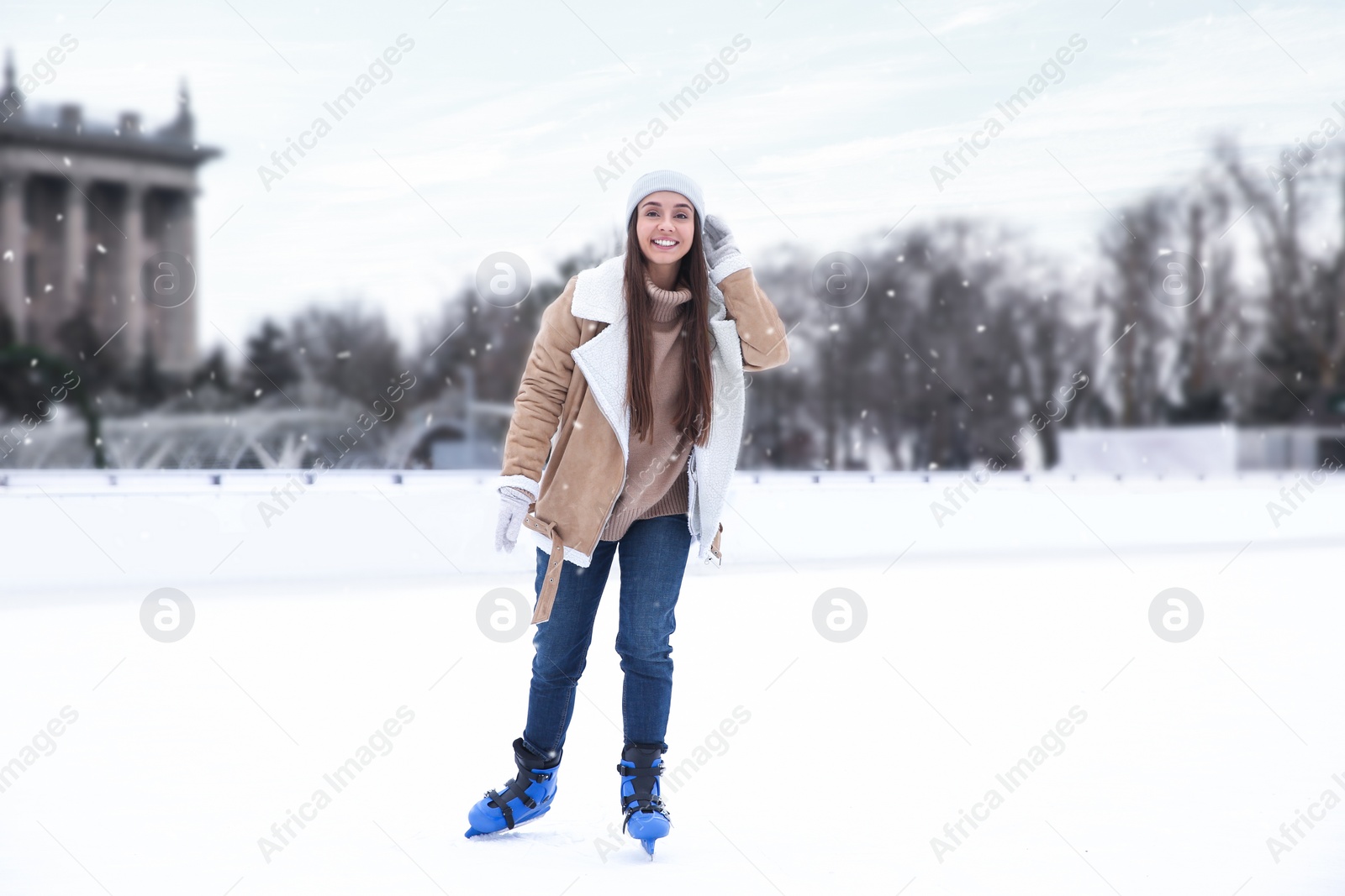 Image of Happy woman skating along ice rink outdoors