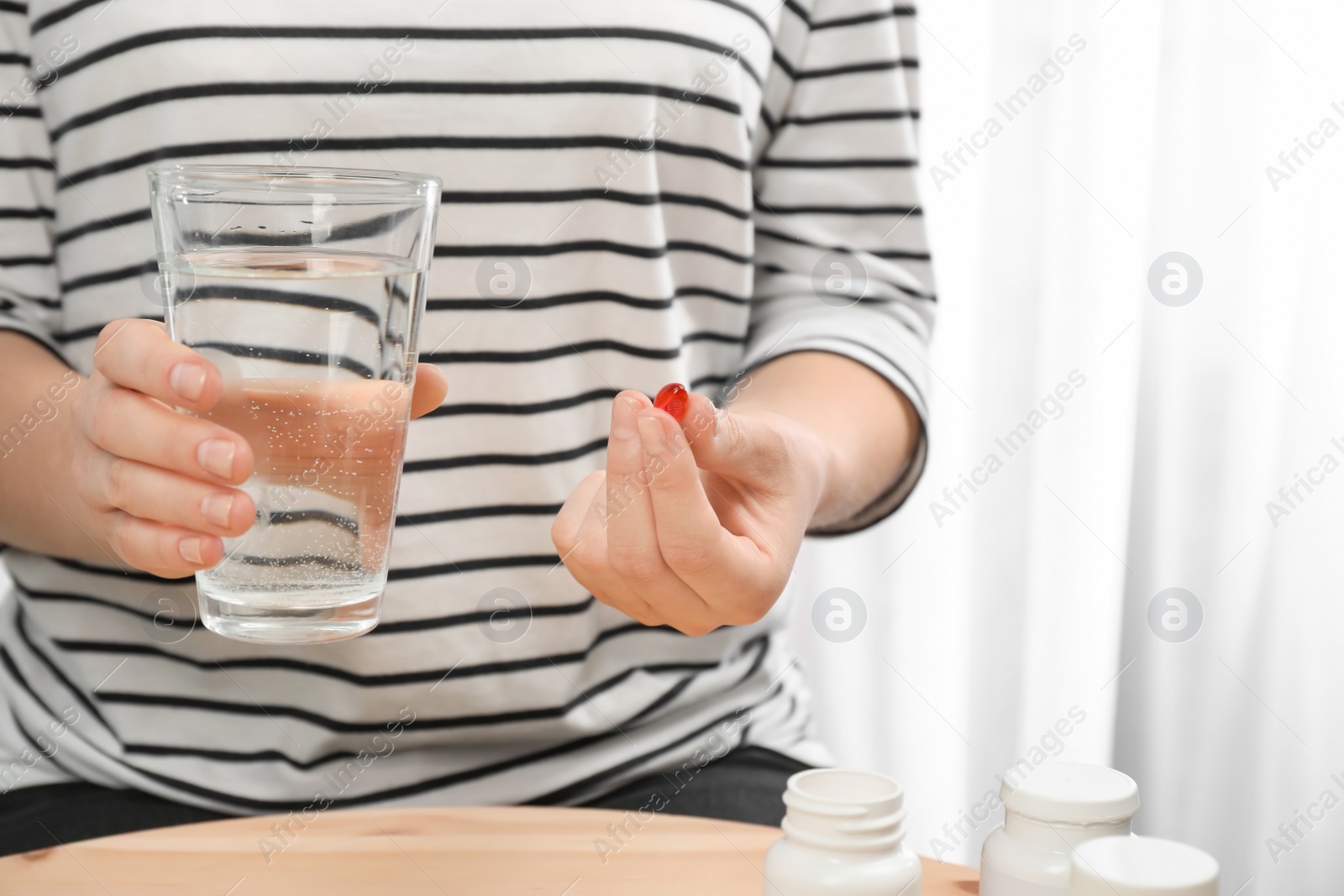 Photo of Young woman taking pill, closeup