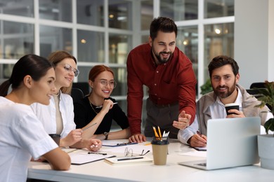 Photo of Team of employees working together in office