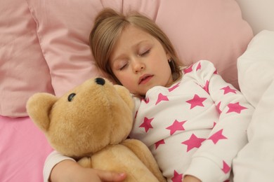 Photo of Little girl snoring while sleeping in bed